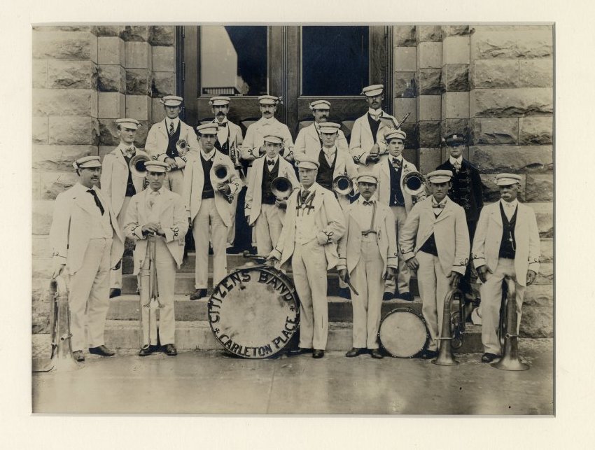 Carleton Place Citizens Band standing on the steps of Carleton Place Town Hall, the drum In front reads "Carleton Place Citizens Band" 