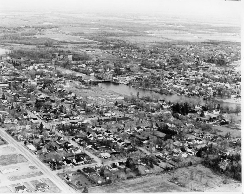 Black and white photograph of an aerial view of Carleton Place. View towards the south east. Findlay Foundry site is empty. Visible: town hall, Bridge street, and others. This photograph was on display at the 2003 International Ploughing Match held just outside Carleton Place.