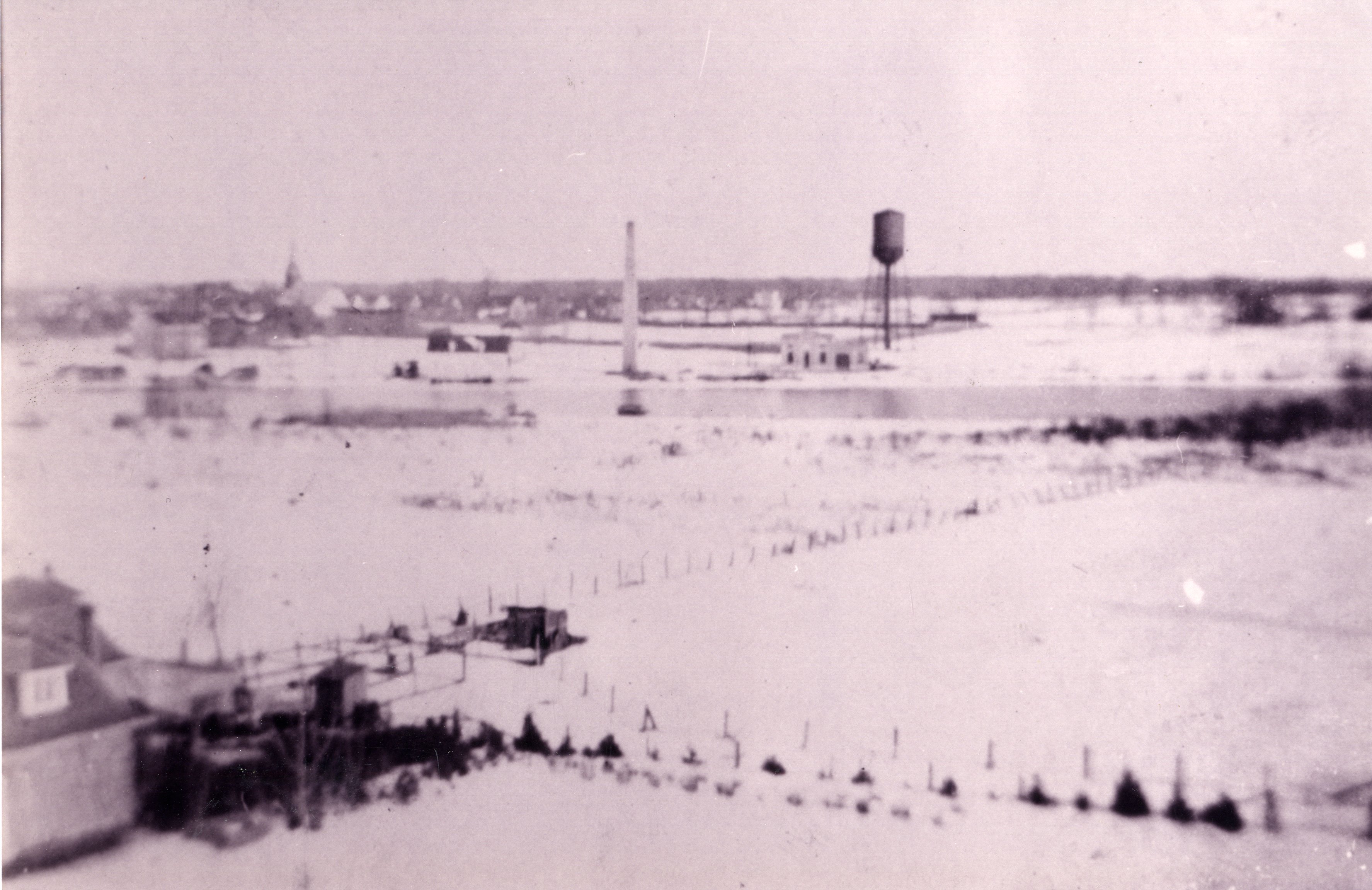 Waterworks can be seen underneath the water tower, past the river. 