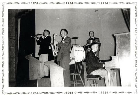 Reprint of a black and white photograph of the band the Top Hats. The photograph shows the members of the band playing their instruments on the stage of the Town Hall in Carleton Place before it was renovated. The photograph shows Art Drader (trumpet), Jack Peckett (sax), Cam Hughes (piano), and Howie Peckett (drums).